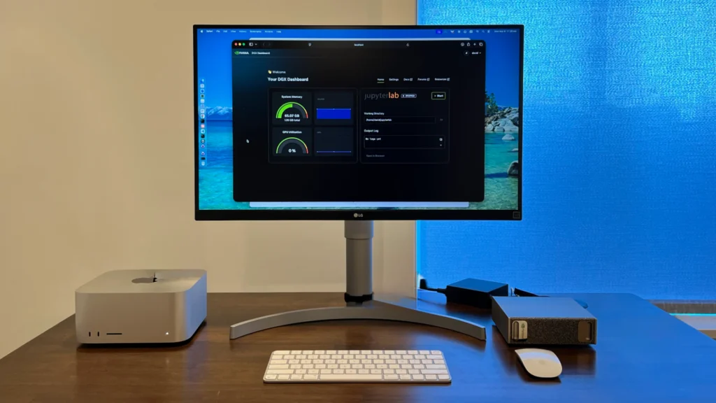 Physical desk setup with an NVIDIA DGX Spark unit, Mac mini, keyboard, and monitor displaying the DGX Dashboard